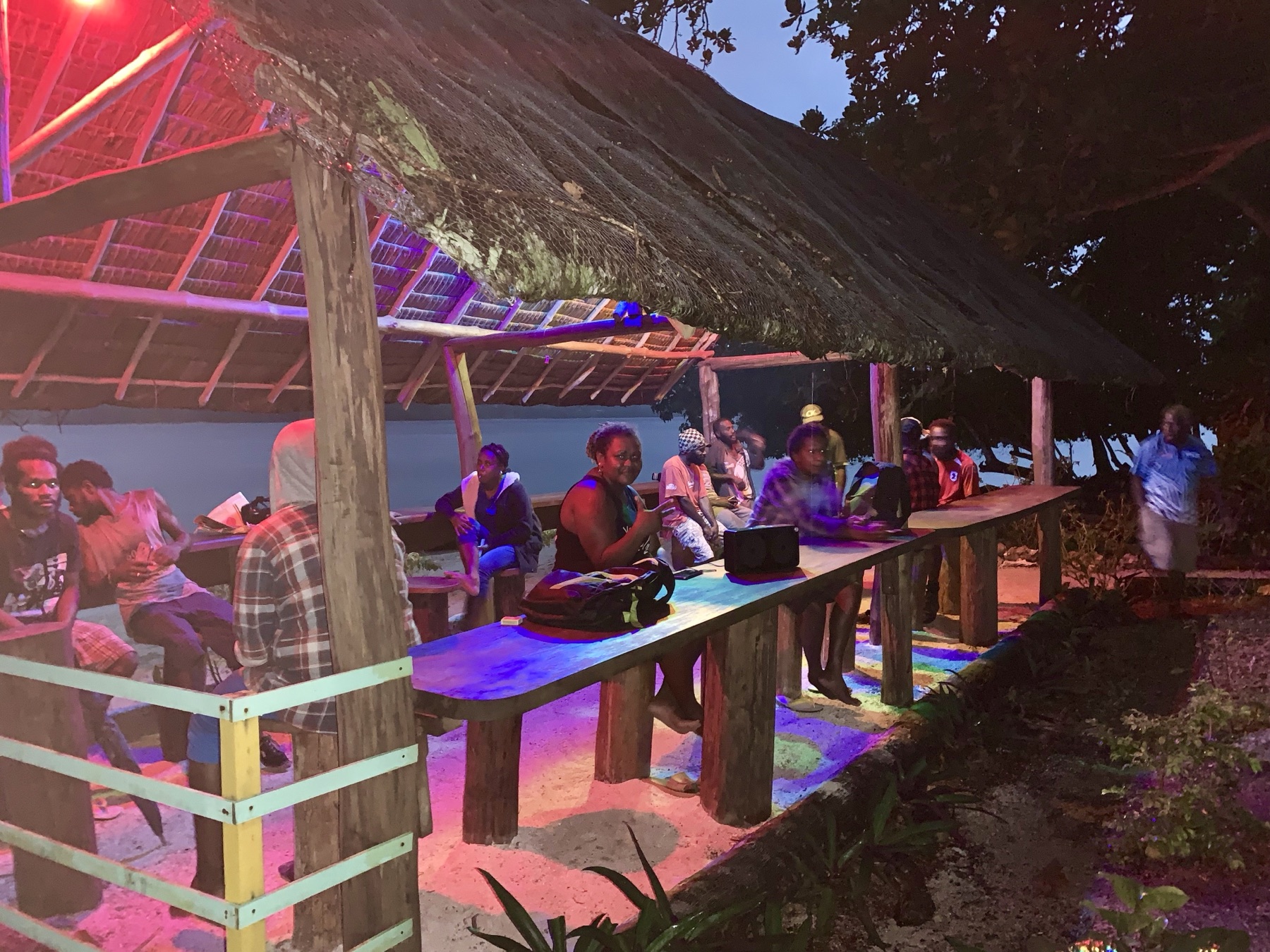 Guests enjoying drinks and island food at Lapita Beach Bar under the thatched fare, Aore Island 2