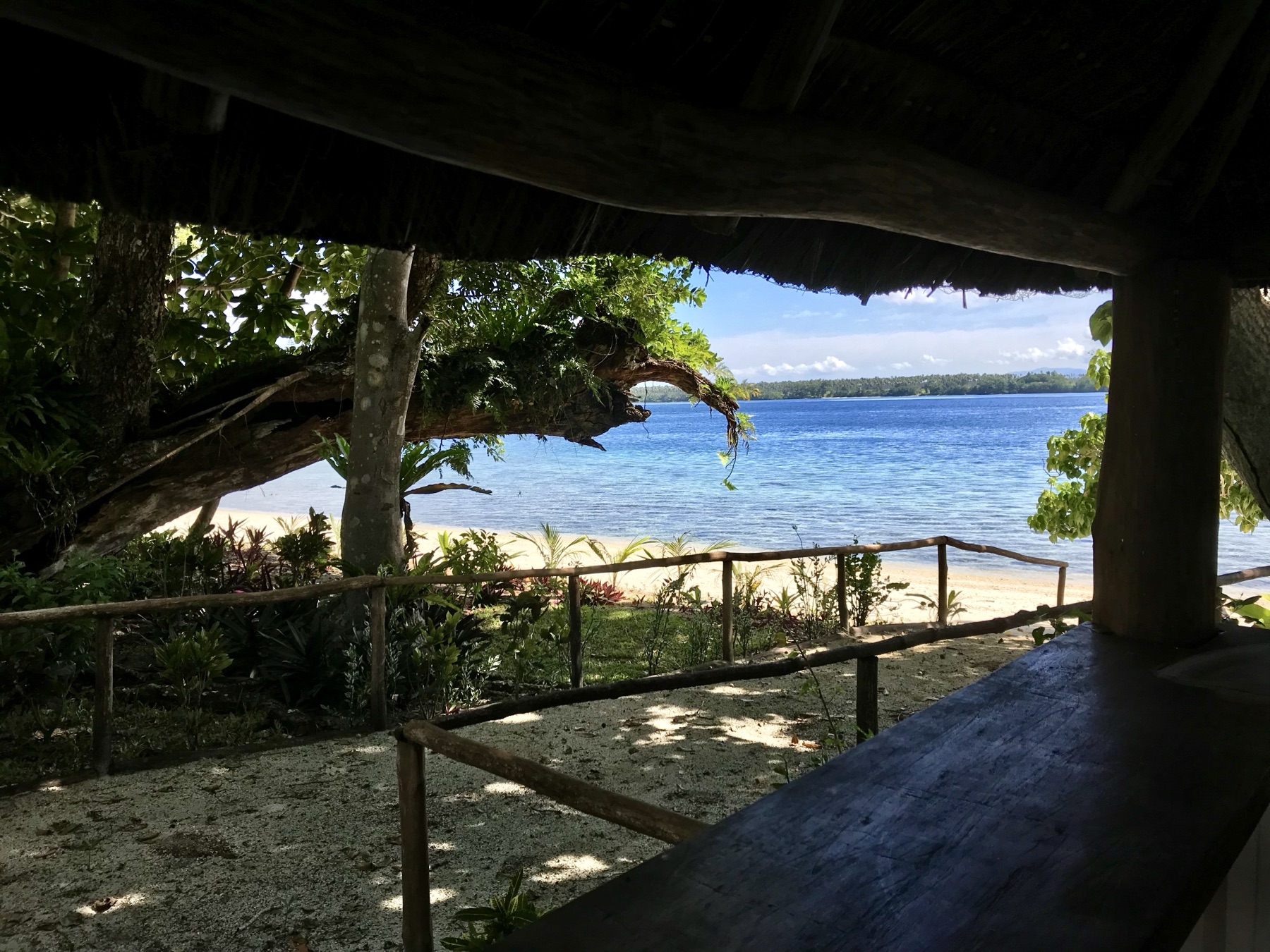 Guests enjoying drinks and island food at Lapita Beach Bar under the thatched fare, Aore Island 6