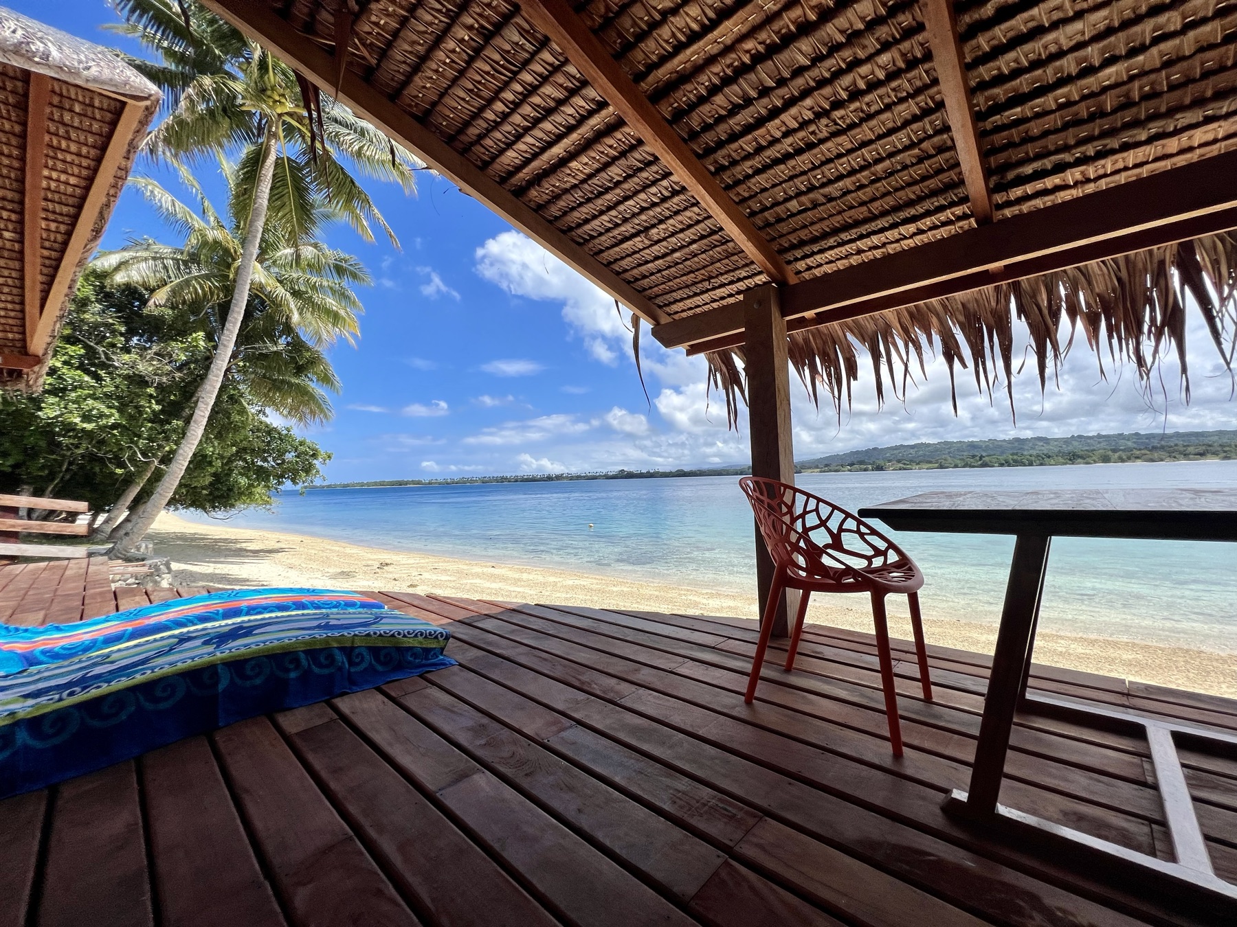 Lapita Beach Villa beachfront deck with day beds and dining under thatch, Aore Island 3