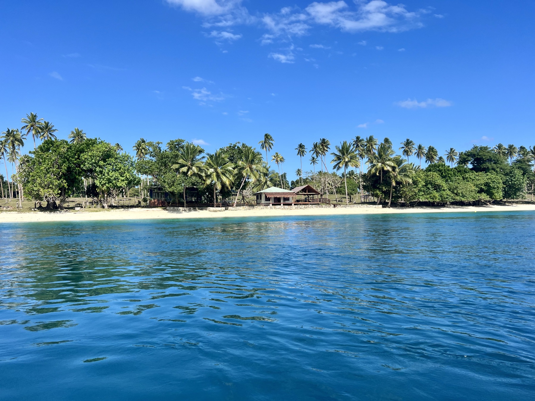 Lapita Beach Villa beachfront deck with day beds and dining under thatch, Aore Island 4