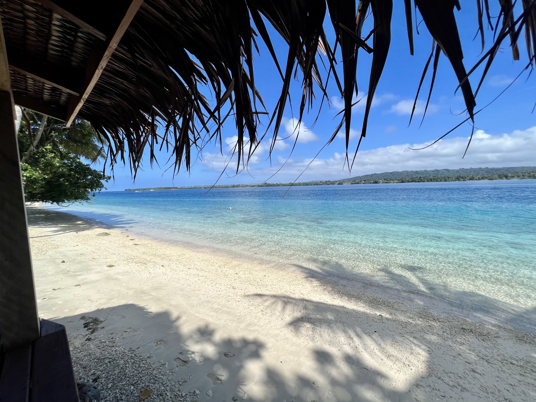Lapita Beach Villa beachfront deck with day beds and dining under thatch, Aore Island 5